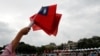 An audience member waves Taiwanese flags during the National Day celebrations in Taipei, Taiwan, Oct. 10, 2018.