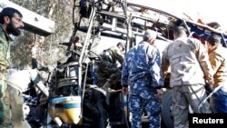 Abasirikare n'abaporisi ba Siriya basuzuma ahasambukiye bisi, hagati i Damas ku murwa mukuru 