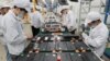 FILE - Workers at a factory for Xinwangda Electric Vehicle Battery Co. Ltd, which makes lithium batteries for electric cars and other uses, in Nanjing in China's eastern Jiangsu province, March 12, 2021.