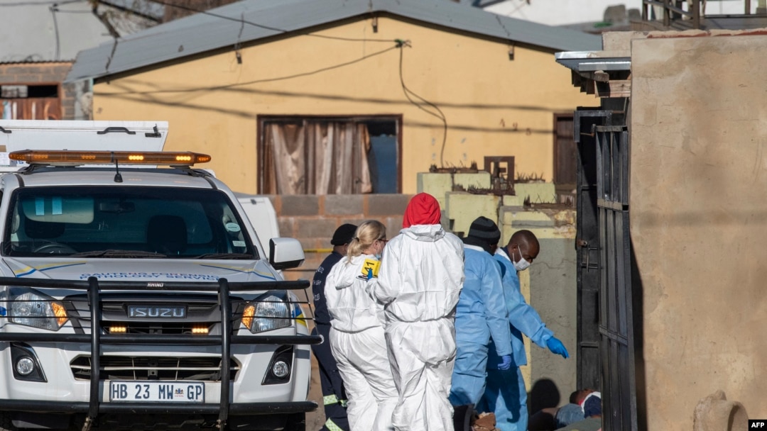 Members of the South African Police Service (SAPS) and forensic pathology service inspect the scene of a mass shooting in Soweto, South Africa, July 10, 2022. 