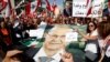 Supporters of Lebanon's President Michel Aoun hold his poster during a rally in Baabda near Beirut, Lebanon, Nov. 3, 2019. 