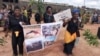 Women protest holding up a poster with images of atrocities committed in an ongoing conflict between government forces and armed separatists, in Bamenda, Cameroon, Sept. 7, 2018. (M.E. Kindzeka/VOA)