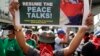 Masked members of the outlawed National Democratic Front of the Philippines, the umbrella organization of the Philippine communist movement, hold a sign during a demonstration in Manila, Philippines, March 25, 2019. 