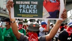 Masked members of the outlawed National Democratic Front of the Philippines, the umbrella organization of the Philippine communist movement, hold a sign during a demonstration in Manila, Philippines, March 25, 2019. 