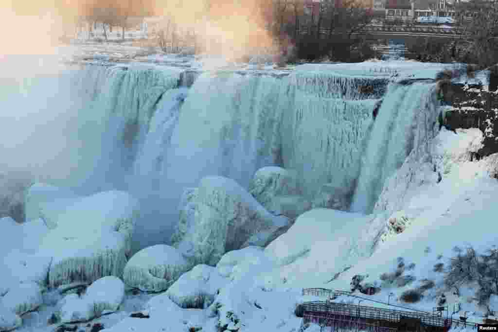 Ice and water flow over the American Falls in Niagara Falls, New York, viewed from the Canadian side, in Niagara, Ontario, Canada, Feb. 12, 2018.
