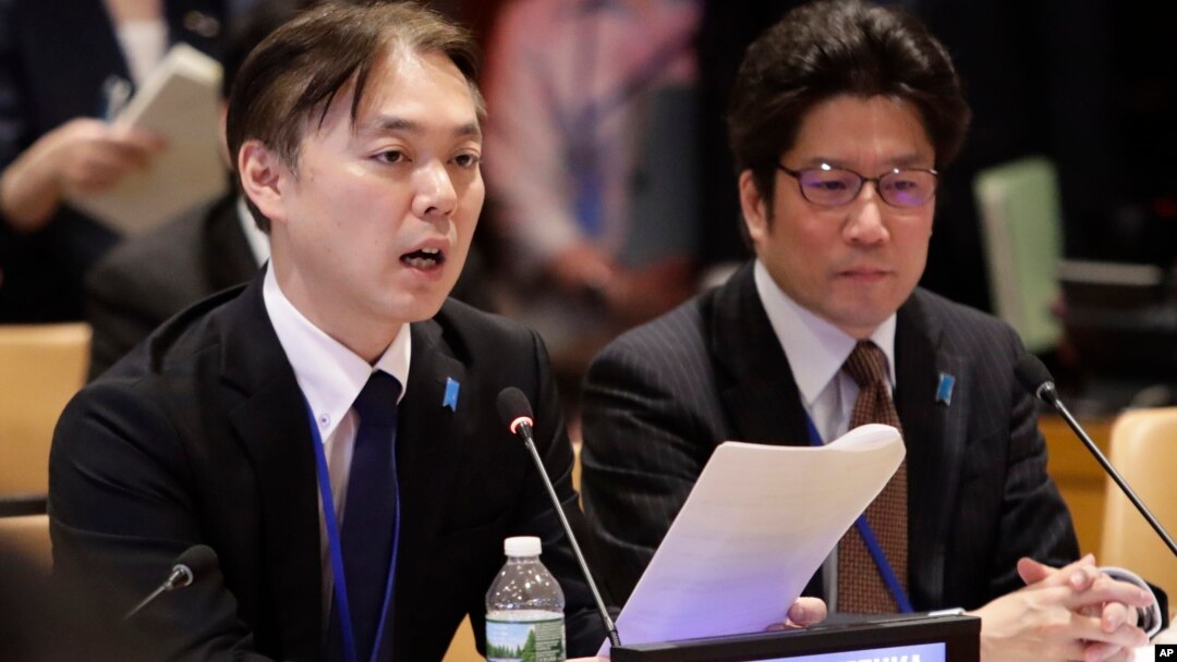Koichiro Iizuka, left, of Japan, speaks during a meeting as Takuya Yokota, right, listens, May 3, 2018, at the United Nations headquarters. 