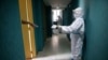 Un médico guarda distancia mientras hace lecturas de frecuencia cardíaca, presión arterial y oxigenación sanguínea de un paciente asintomático con COVID-19 en cuarentena en un hotel en Caracas, Venezuela. Julio 24, 2020.