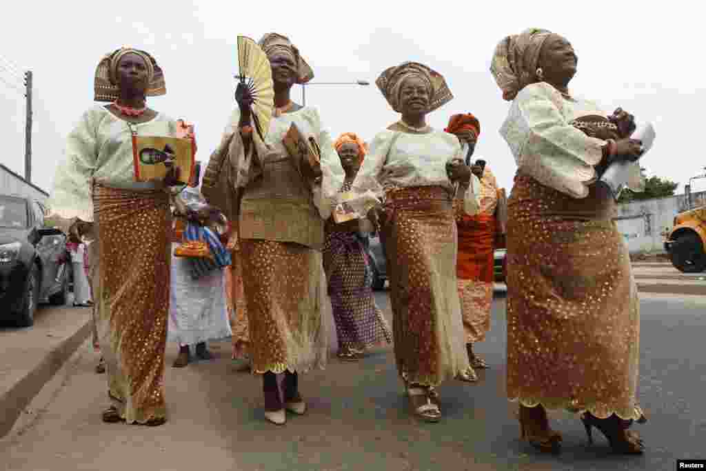 Family members of a deceased person walk along a road near a cemetery during a funeral ceremony in Lagos, Nigeria, May 31, 2013.