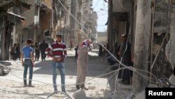Cư dân kiểm tra thiệt hại sau một cuộc không kích ở al-Maysar, Aleppo, Syria, ngày 11/4/2016.