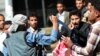 A Shi'ite Houthi rebel threatens Yemeni protesters during a rally against the control of the capital by Houthi rebels, Jan. 24, 2015.