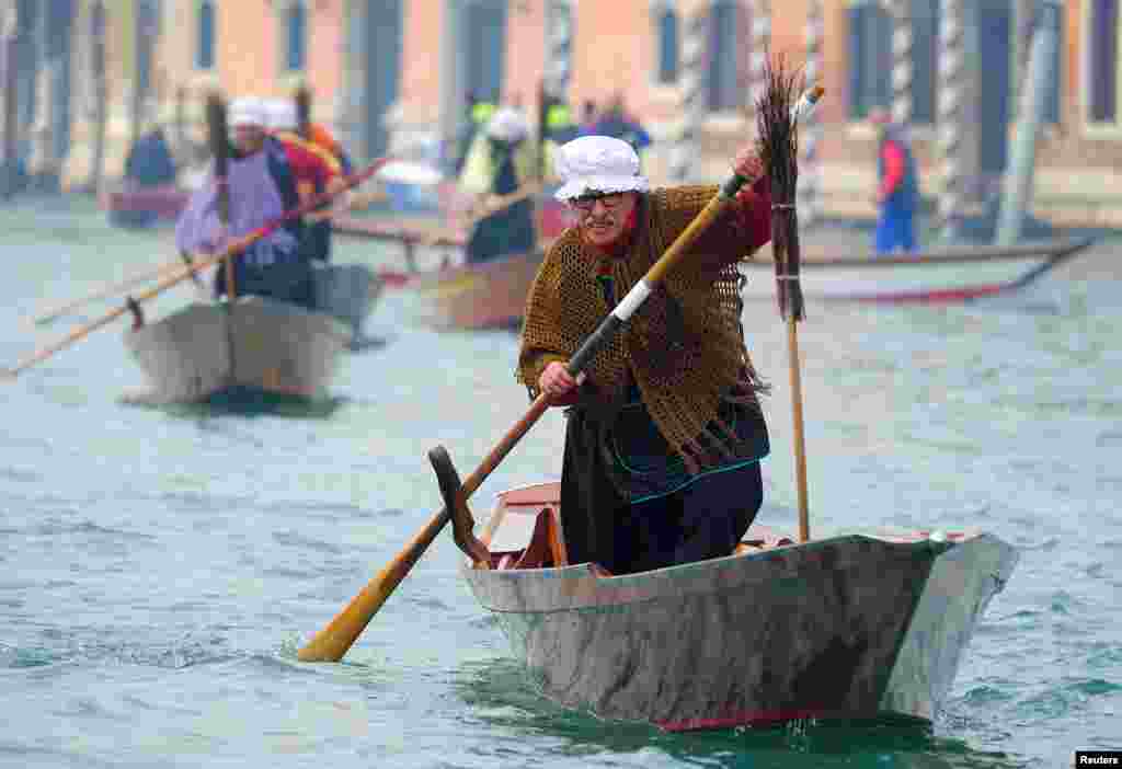 Men dressed as &quot;La Befana,&quot; an imaginary old woman who is thought to bring gifts to children during the festival of Epiphany, row boats down the Grand Canal in Venice, Italy, Jan. 6, 2018.