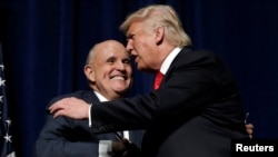FILE - Republican presidential nominee Donald Trump embraces former New York City Mayor Rudolf Giuliani at a campaign rally in Greenville, N.C., Sept. 6, 2016.