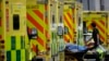 FILE - A patient is pushed on a trolley after arriving in an ambulance outside the Royal London Hospital in the Whitechapel area of east London, Thursday, Jan. 6, 2022. 