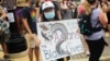 一名手持中文牌子的抗议者参加在华盛顿2020年6月6日举行的反警暴游行。（美国之音记者文灏拍摄）