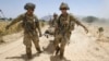 U.S. Army soldiers carry Sgt. Matt Krumwiede, who was wounded by an improvised explosive device (IED), towards a Blackhawk Medevac helicopter in southern Afghanistan June 12, 2012.
