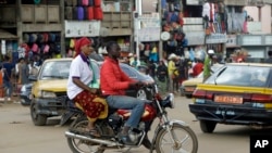 FILE - A motorbike taxi rides past Mokolo Market in Yaounde, Cameroon, Oct. 11, 2018.