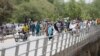 FILE - People cross a bridge linking Cameroon and Nigeria at Gamboru/Ngala in Borno, Nigeria, April 27, 2017. 
