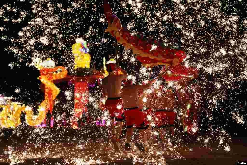 Folk artists perform a fire dragon dance under a shower of sparks from molten iron, ahead of the Chinese Lunar New Year, in Shangqiu, Henan province, China, Feb. 14, 2018.