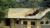 FILE - A woman stands outside a damaged school dormitory after it was set on fire in Bafut, in the northwest English-speaking region of Cameroon, Nov. 15, 2017. The military says it is helping clean up towns in efforts to implement new peace resolutions.