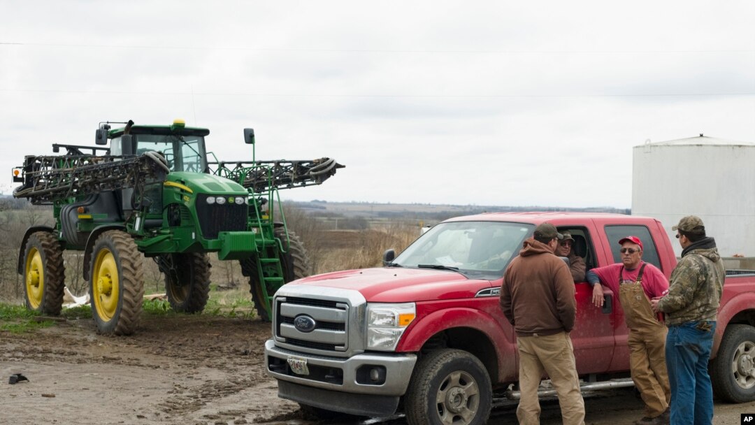 FILE - In this April 4, 2017, photo, Blake Hurst, a corn and soybean farmer and president of the Missouri Farm Bureau, second right, talks with his son Dallas Hurst, right, and his brothers Brooks Hurst, left, and Kevin Hurst, second left, on his farm in