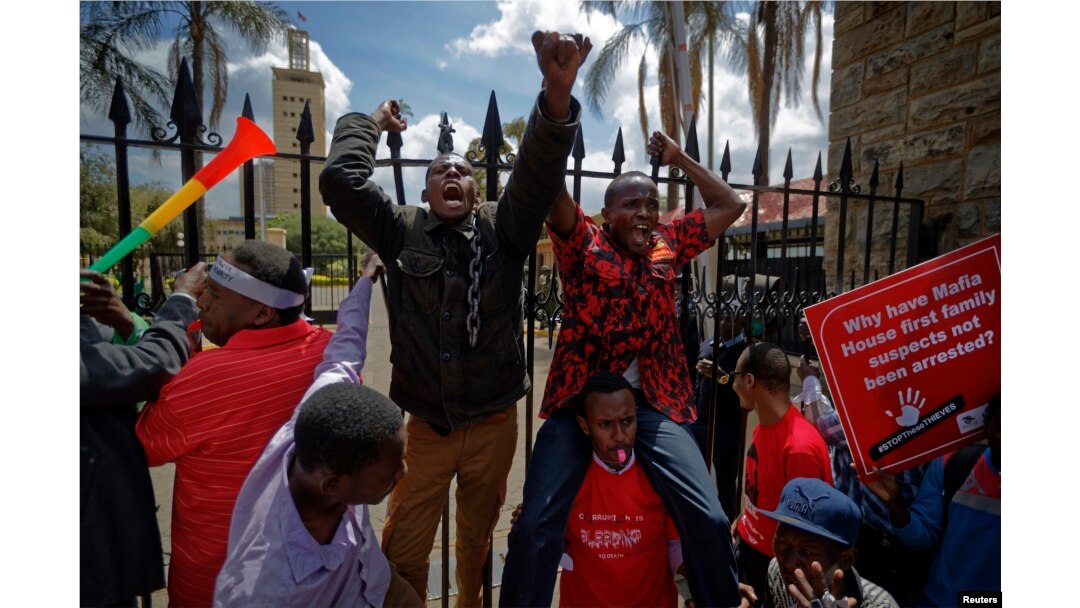 Protesters briefly climb the gates of Parliament, one holding a placard referring to President Uhuru Kenyatta, during an anti-corruption demonstration in Nairobi, Kenya, May 31, 2018.