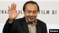 FILE - Cambodian director Rithy Panh waves as he poses during a photo call, Oct. 24, 2008.