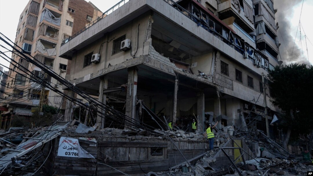 Emergency workers inspect a building that was hit in an Israeli airstrike in Dahiyeh, Beirut, Lebanon, Oct. 6, 2024. 