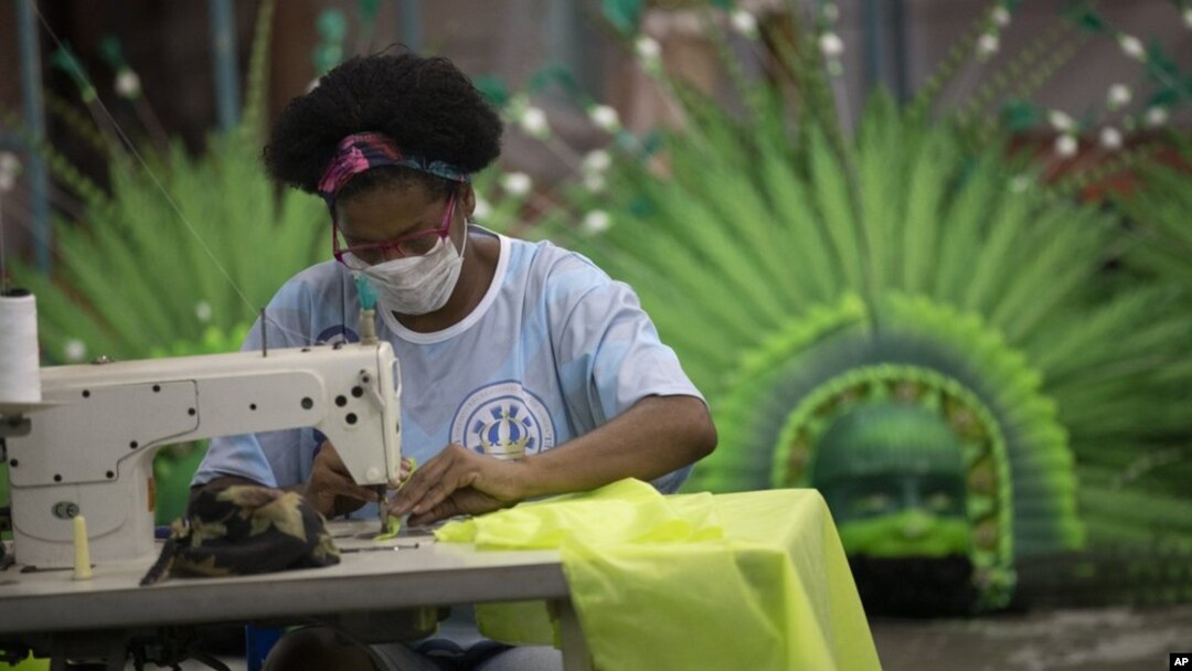 Carmen, a worker from the Vila Isabel samba school makes a medical scrub, during the new coronavirus pandemic in Rio de Janeiro, Brazil, Tuesday, April 7, 2020. (AP Photo/Silvia Izquierdo)
