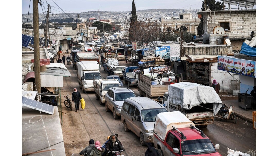 FILE - Civilians flee from Idlib toward the north to find safety inside Syria near the border with Turkey, Feb. 15, 2020.