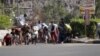 People seek shelter from gunfire at an army base in Yemen's southern port city of Aden, March 25, 2015. 