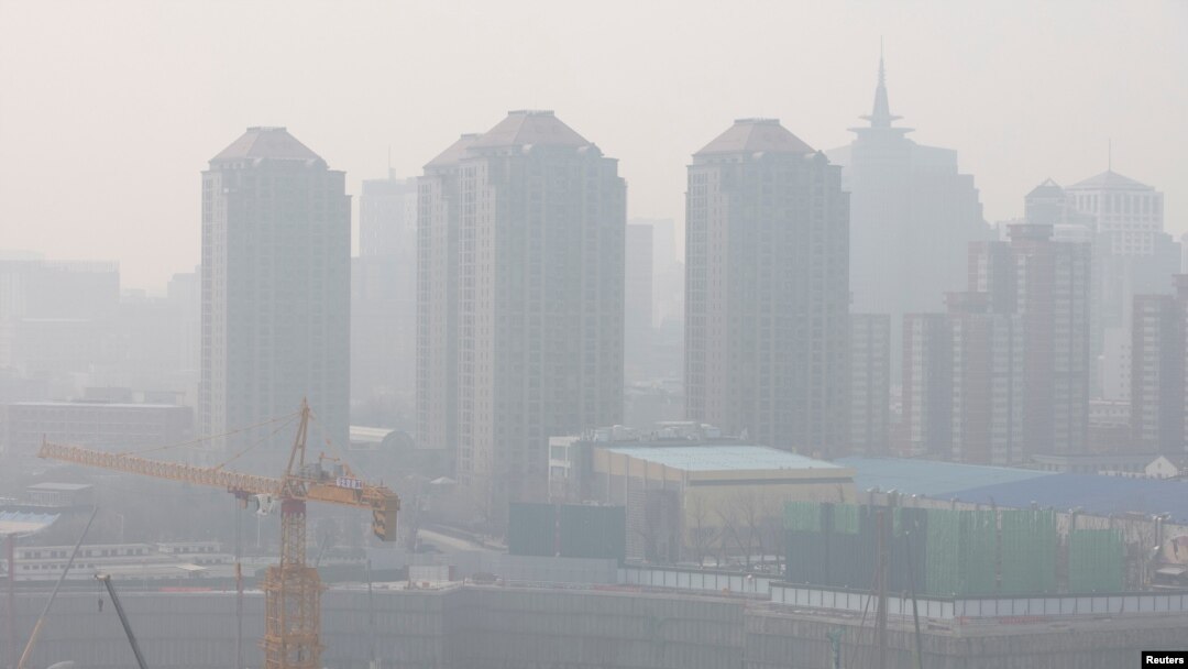FILE - A construction site is seen against the backdrop of skyscrapers on a day with high air pollution in Beijing, China, March 11, 2021.