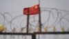 资料照：中国国旗在新疆喀什一处由铁丝网围绕的设施附近飘扬。 