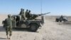 FILE - Afghan National Army soldiers stand guard at a checkpoint on the way to the Sangin district of Helmand province, Afghanistan, Dec. 23, 2015.