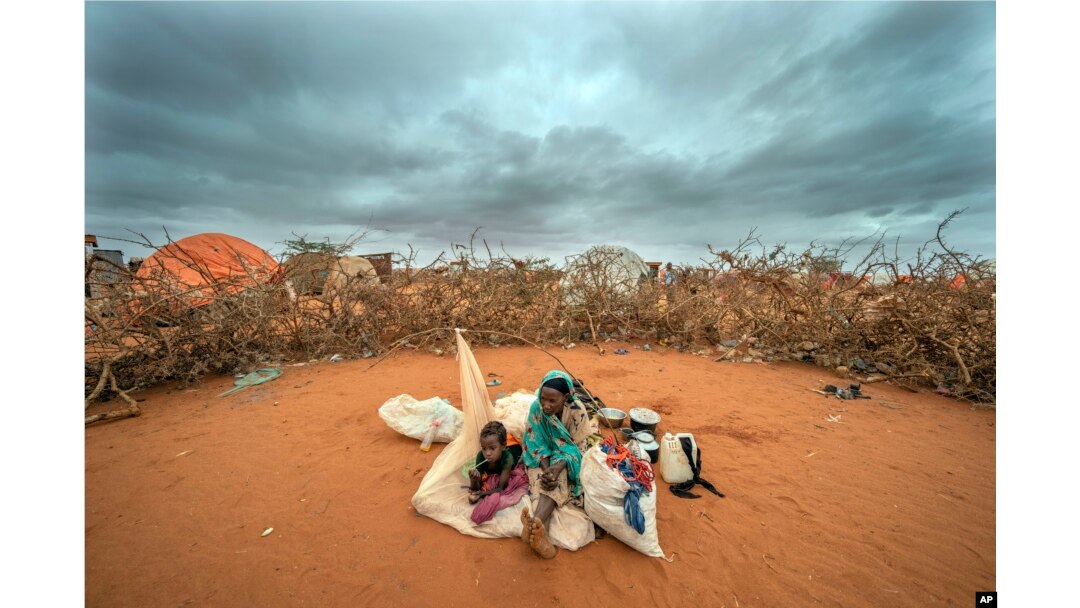 FILE - A Somali woman and child wait to be given a spot to settle at a camp for displaced people on the outskirts of Dollow, Somalia on Tuesday, Sept. 20, 2022. (AP Photo/Jerome Delay, File)