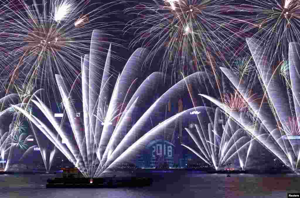 Fireworks explode over Victoria Harbour and Hong Kong Convention and Exhibition Centre to celebrate the New Year.