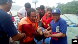 Coast guard rescuers and volunteers carry a victim after being retrieved from the waters off Guimaras, Aug. 4, 2019 in Iloilo province in central Philippines.