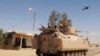 FILE - In this Tuesday, May 12, 2013 file photo, Egyptian Army soldiers patrol in an armored vehicle backed by a helicopter gunship during a sweep through villages in Sheikh Zuweyid, north Sinai, Egypt. An Egyptian militant group affiliated with the Islam