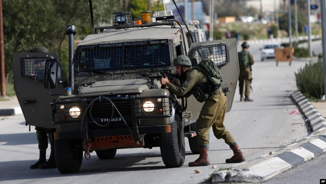 Israeli soldiers conduct a search for suspects of a shooting attack yesterday in the West Bank City of Ramallah, Dec. 10, 2018.