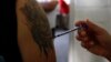 FILE - A man receives a dose of flu vaccine.