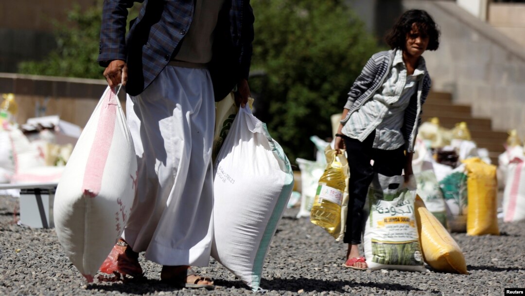 A young woman carries food received from a local charity during the holy month of Ramadan in Sanaa, Yemen, May 29, 2017. 