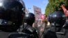 FILE - Protesters confront riot police during an anti-government rally along Habib Bourguiba avenue in Tunisia's capital Tunis, Oct. 10, 2021.