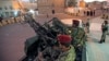 Houthi fighters in army uniforms patrol outside the presidential palace in Sana'a, Yemen, Feb. 6, 2015.