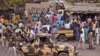 File - Nigerian soldiers ride on the back of an armed truck as they patrol at a local market Tuesday, Jan. 27, 2015, after recent violence in surrounding areas at Maiduguri, Nigeria. Islamic extremists are rampaging through villages in northeast Nigeria’s