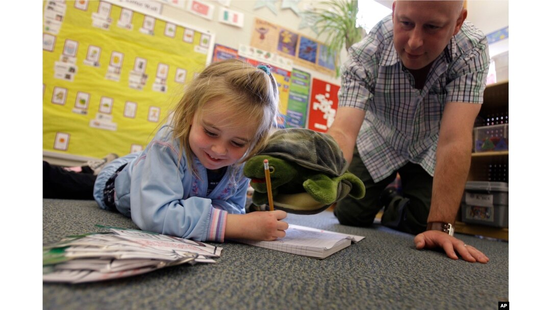 Teacher Matt Bugaj uses a Twiggle the Turtle hand puppet to teach a "Twiggle the Turtle" conflict resolution lesson to Kaylee Schaefer, 4, at Bennett Family Child Care Center in University Park, Pa., Friday, Nov. 14, 2008. (AP Photo/Carolyn Kaster)