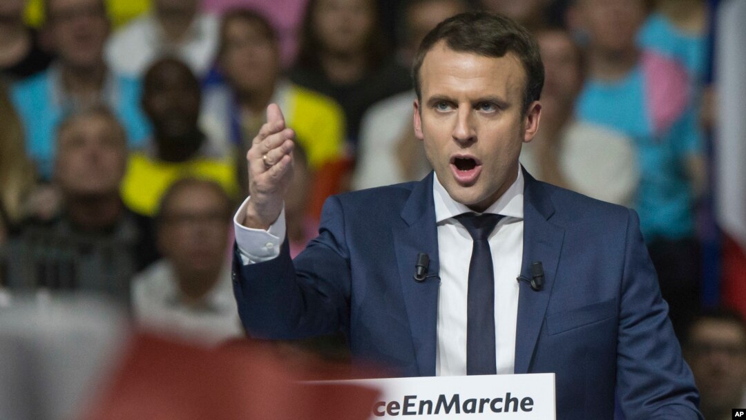 Supporters of French presidential candidate Emmanuel Macron hold placards as he speaks during a campagin rally in Lyon, central France, Feb. 4, 2017.
