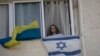 Ukrajinska izbjeglica u Izraelu Tatjana Prima sa zastavama dvije zemlje u stanu, u Aškelonu (Foto: AP/Maya Alleruzzo)