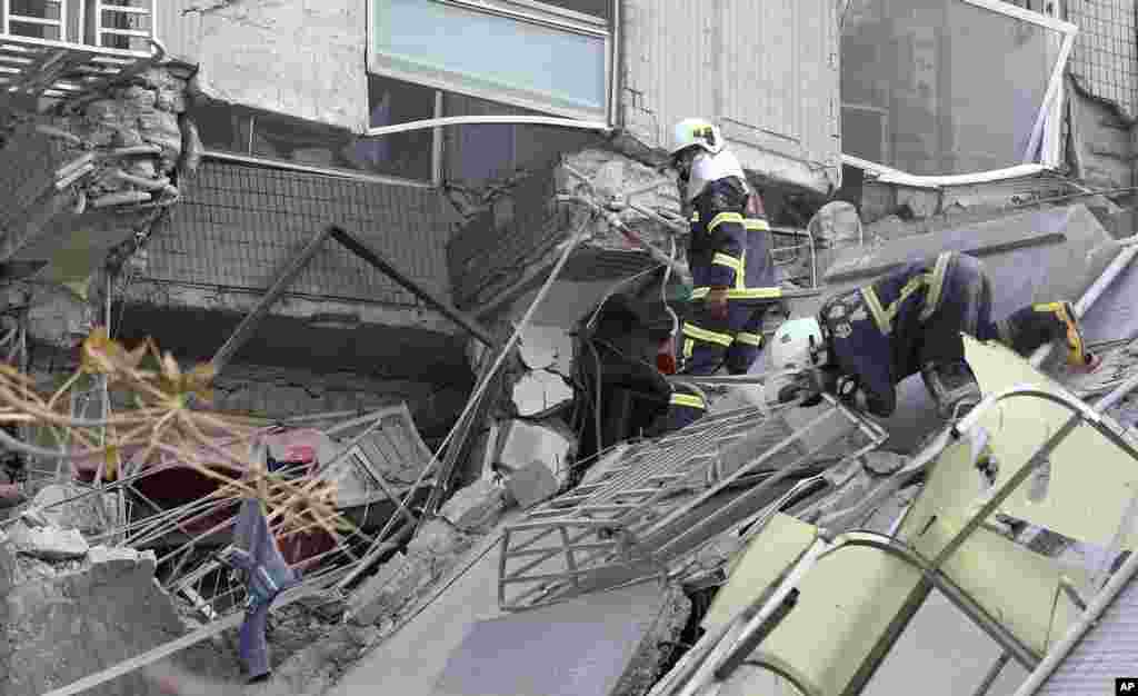 Emergency rescue teams search for victims in a crumbled building.