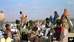 FILE - Somali refugees wait for a plane to take them home from Dabaab refugee camp in northern Kenya.