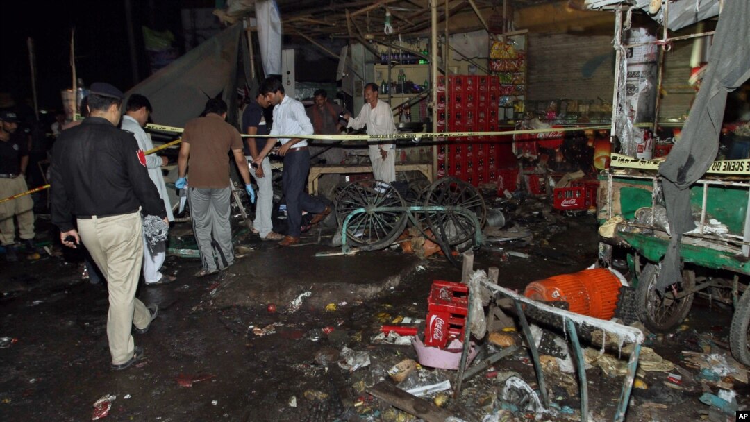 Pakistani police and security officers examine the site of an explosion in Multan, Pakistan, Sunday, Sept. 13, 2015. 