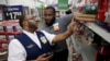FILE - A Walmart employee, left, is coached by a trainer to use an inventory app at a Walmart store in North Bergen, New Jersey, Nov. 9, 2017.